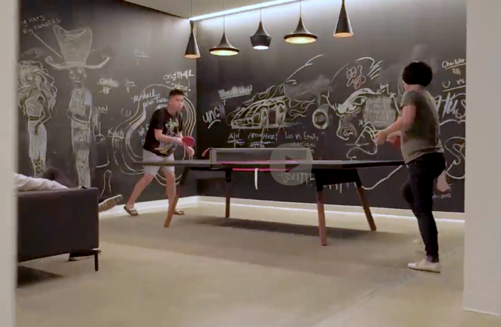 Two males playing ping pong